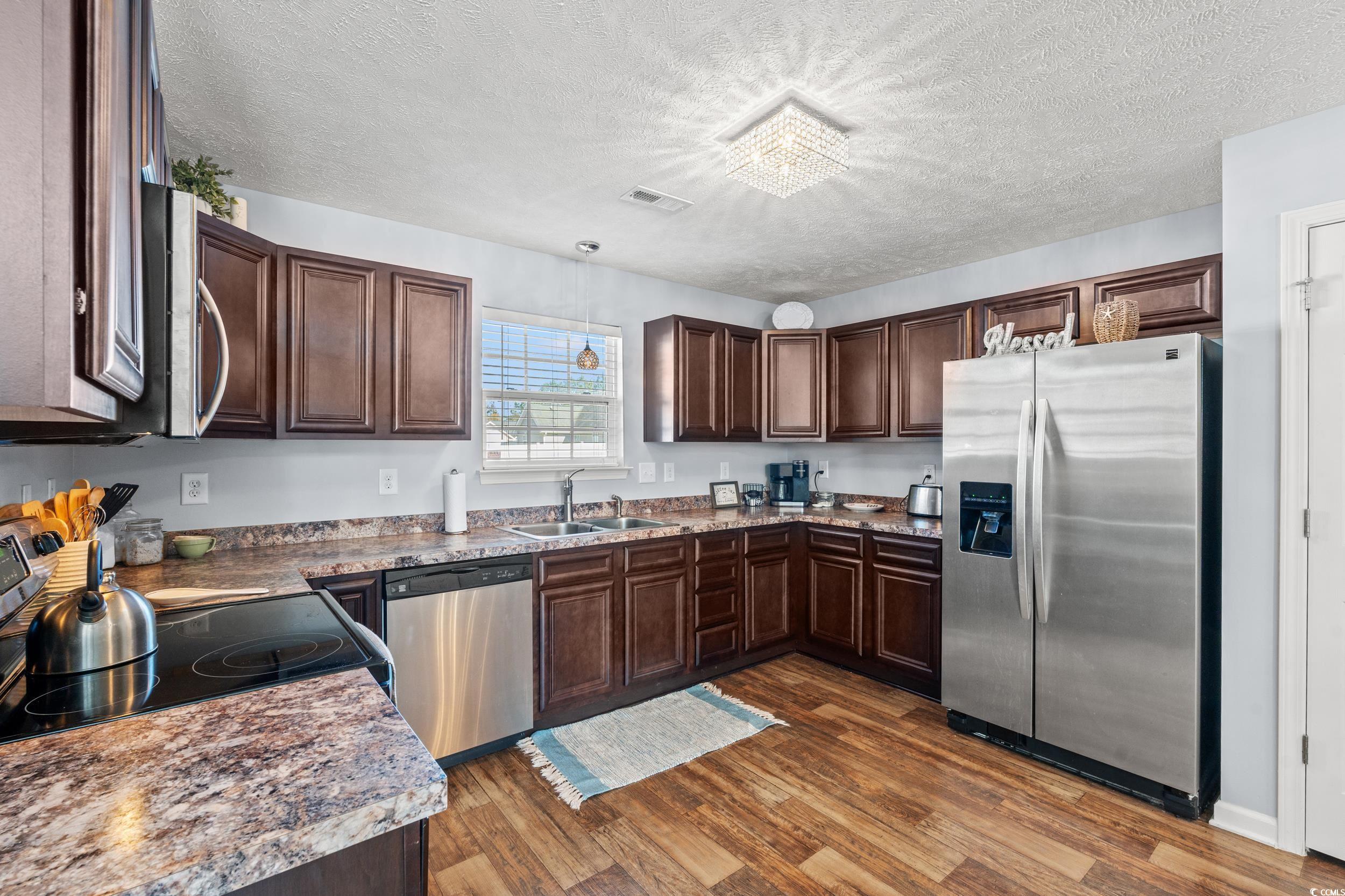 166 Woodland Park Loop Murrells Inlet, SC 29576 - Photo 6 of 39 Kitchen featuring a textured ceiling, dark hardwoo