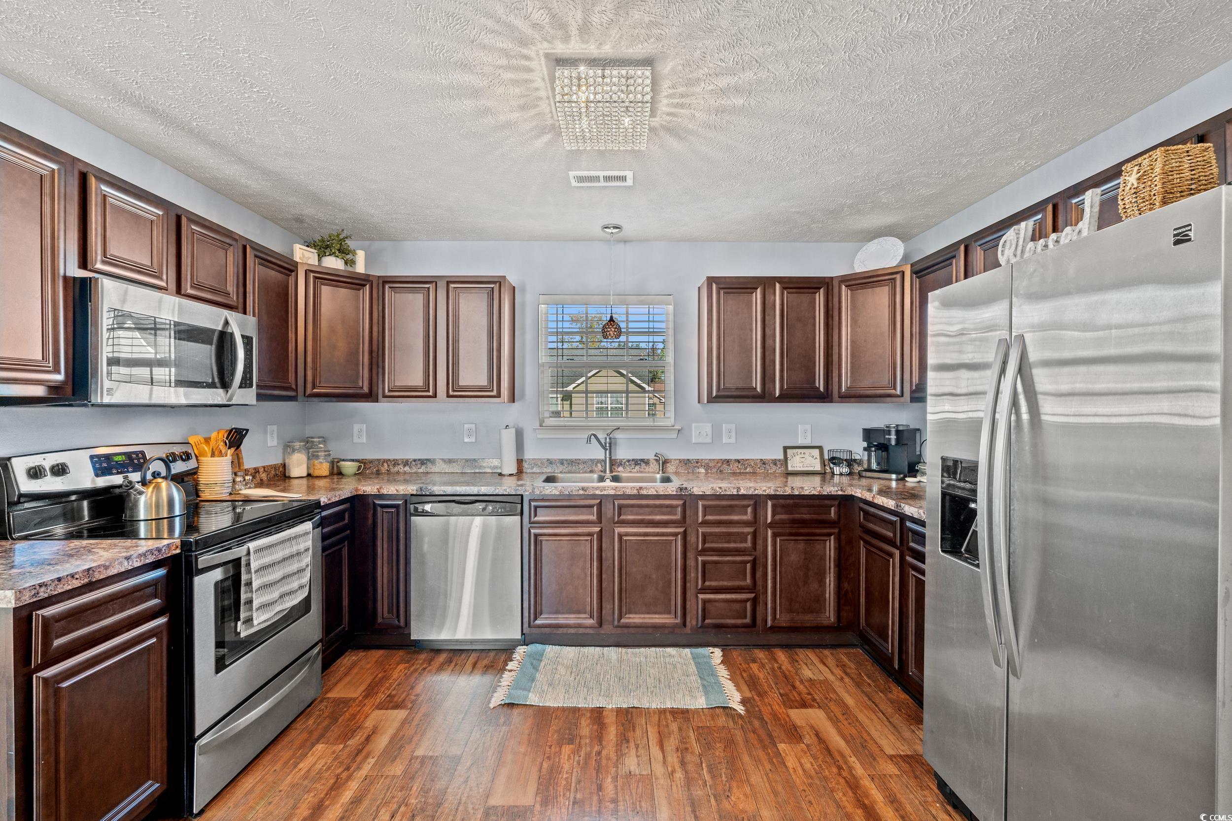 166 Woodland Park Loop Murrells Inlet, SC 29576 - Photo 8 of 39 Kitchen featuring a textured ceiling, dark hardwoo