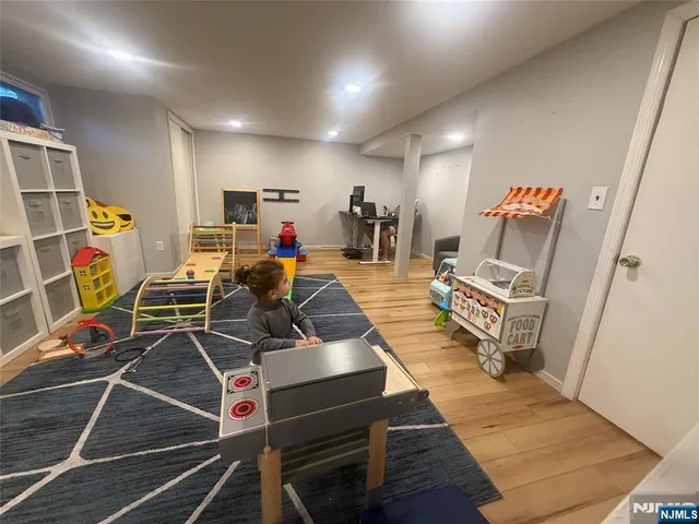 a living room with furniture a flat screen tv and gym equipment