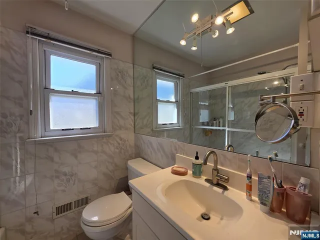 a bathroom with a toilet a sink a mirror and vanity
