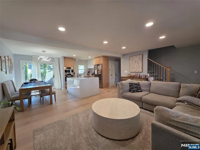 a living room with furniture and a dining table with kitchen view