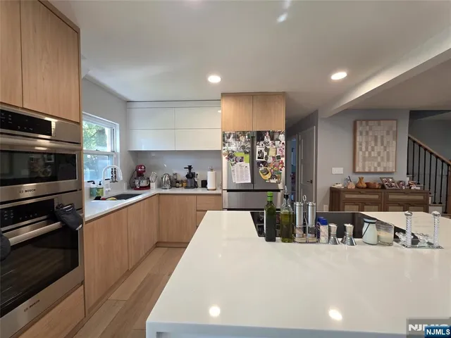 a kitchen with stainless steel appliances kitchen island granite countertop a refrigerator and stove top oven