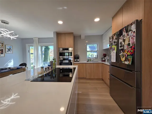 a large kitchen with kitchen island a large counter top space a sink a stove and a refrigerator