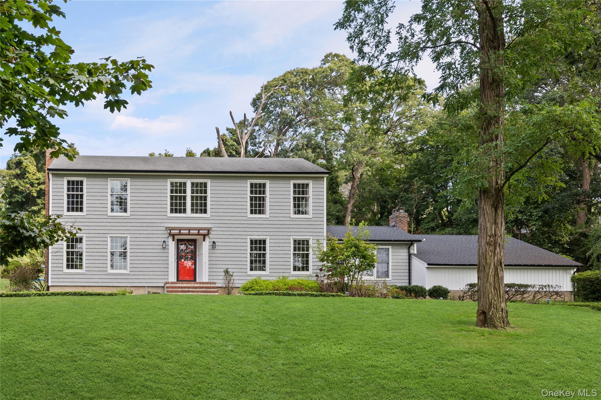 a front view of a house with a garden and yard