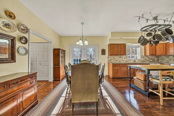 a view of a hallway to a livingroom with wooden floor fireplace and windows