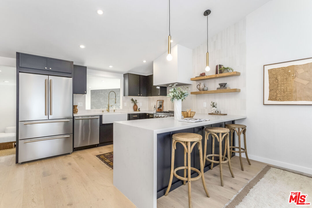 950 North Summit Avenue Pasadena, CA 91103 - Photo 14 of 37 a kitchen with stainless steel appliances granite countertop a sink a stove a refrigerator and island with wooden floor