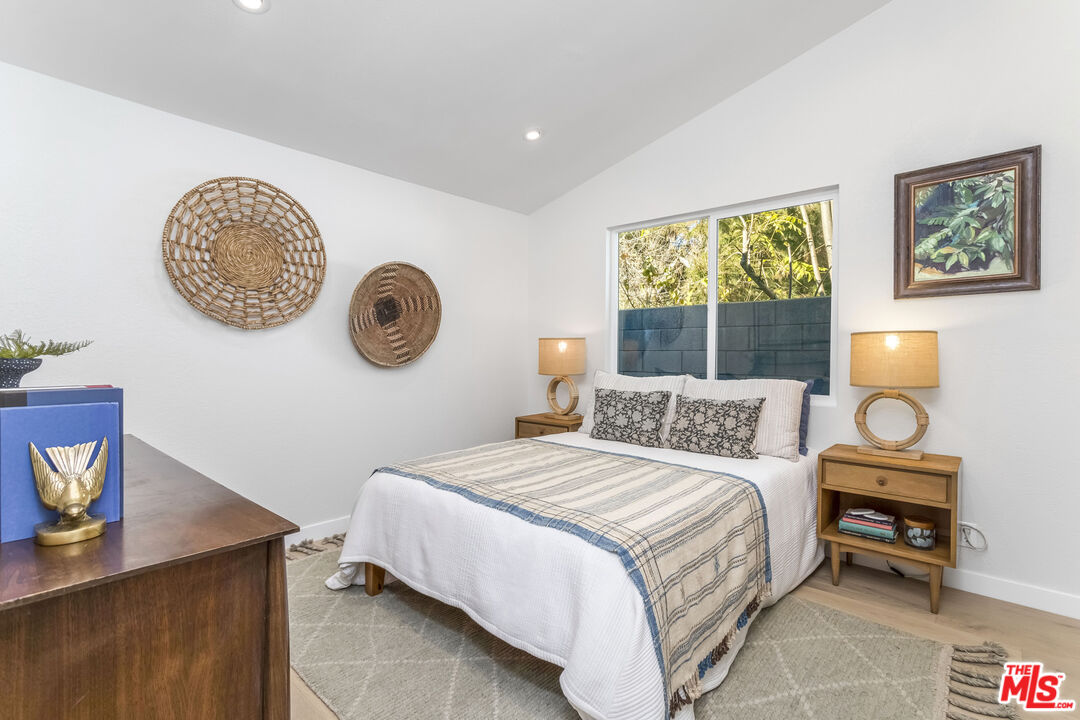 950 North Summit Avenue Pasadena, CA 91103 - Photo 29 of 37 a bedroom with a bed and a lamp on table next to a window