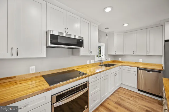 a kitchen with granite countertop a sink a stove and cabinets