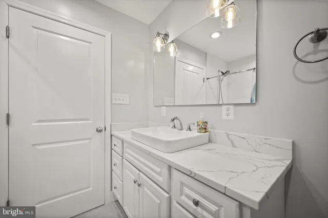 a bathroom with a granite countertop sink a shower and a mirror