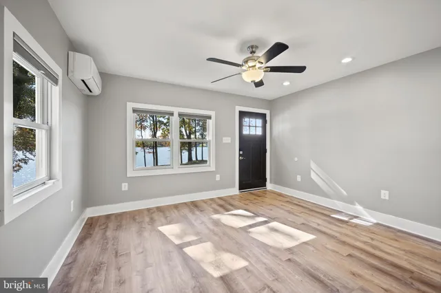 an empty room with windows and ceiling fan