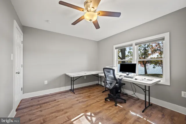 a view of room with wooden floor and ceiling fan