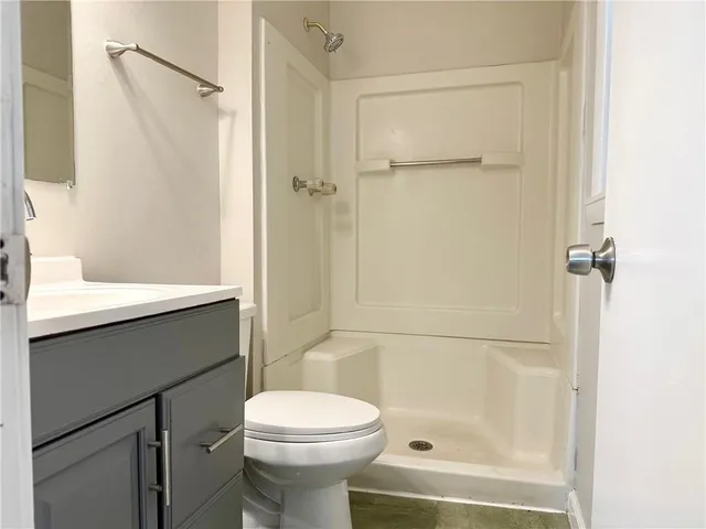a bathroom with a sink a toilet and shower