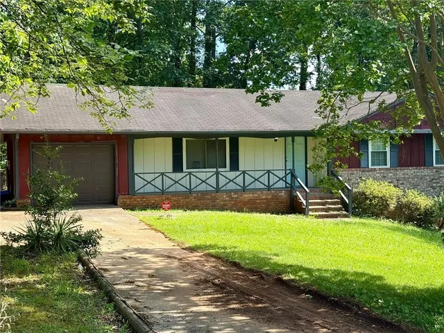 a front view of a house with yard and green space