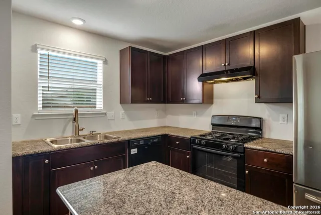 a kitchen with a sink stove and refrigerator