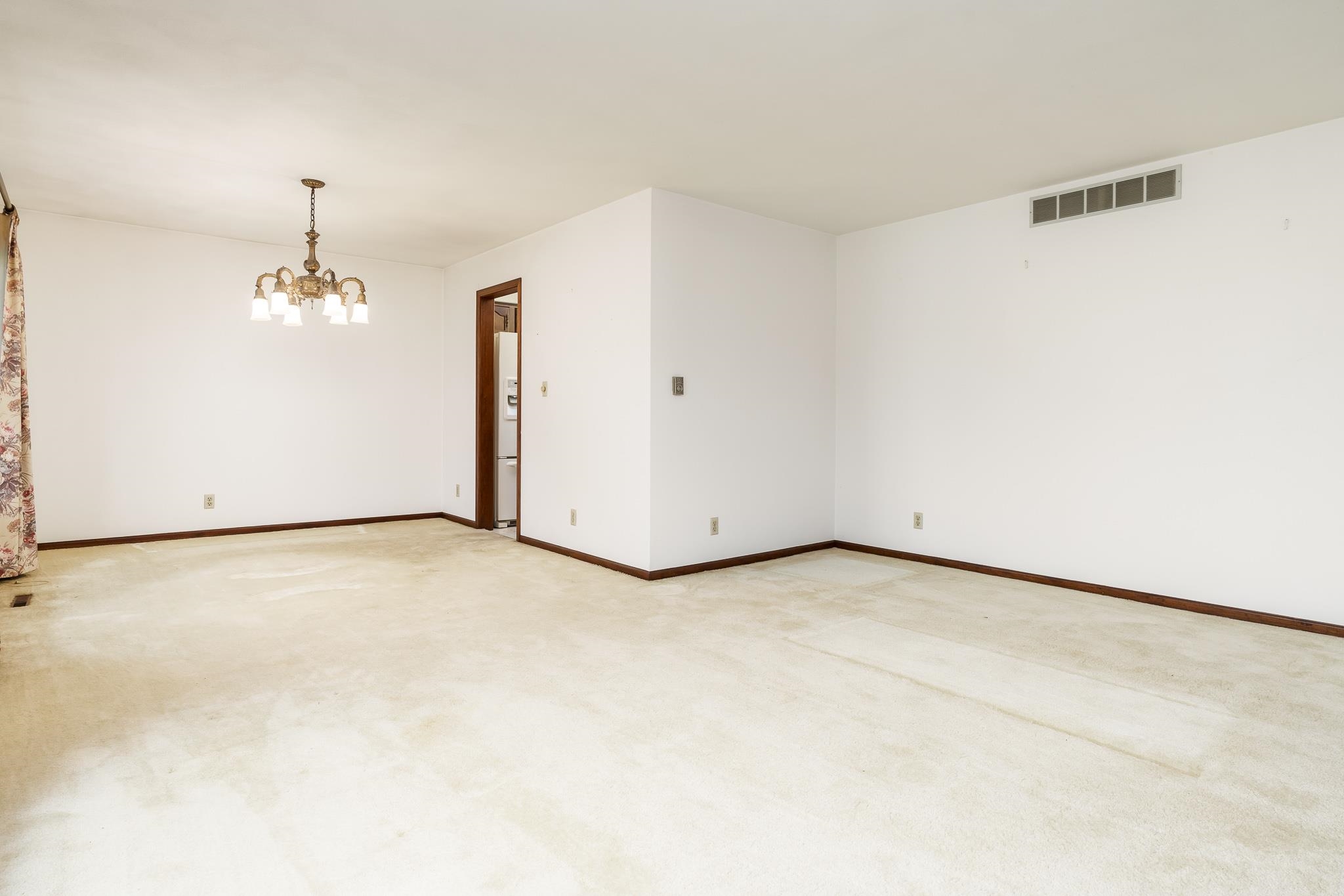 6644 Belvidere Road Roscoe, IL 61073 - Photo 12 of 42 an empty room with a chandelier fan and windows
