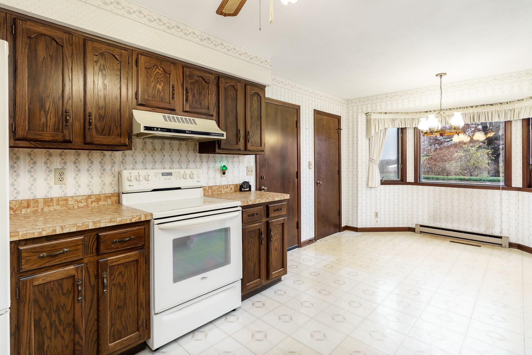 6644 Belvidere Road Roscoe, IL 61073 - Photo 18 of 42 a kitchen with stainless steel appliances granite countertop a stove a sink and a refrigerator