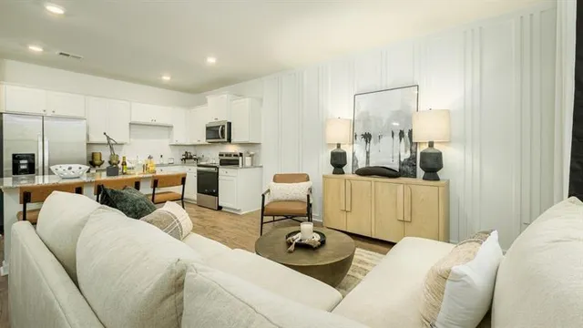a living room with furniture and a view of kitchen