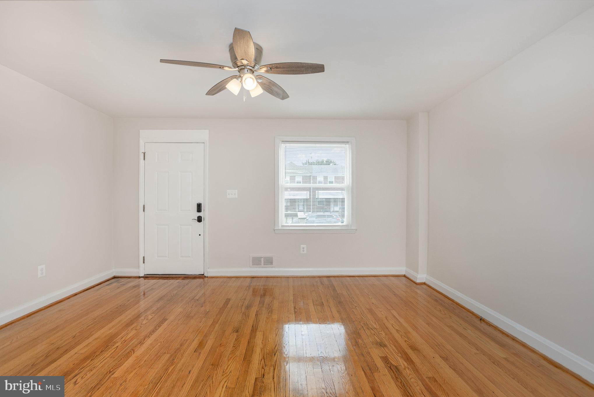 53 South Hawthorne Road Middle River, MD 21220 - Photo 4 of 29 an empty room with wooden floor chandelier fan and windows