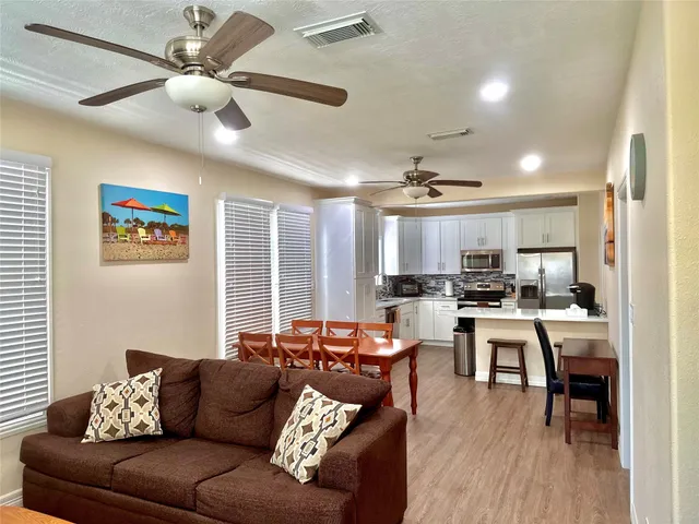 a living room with furniture kitchen view and a large window