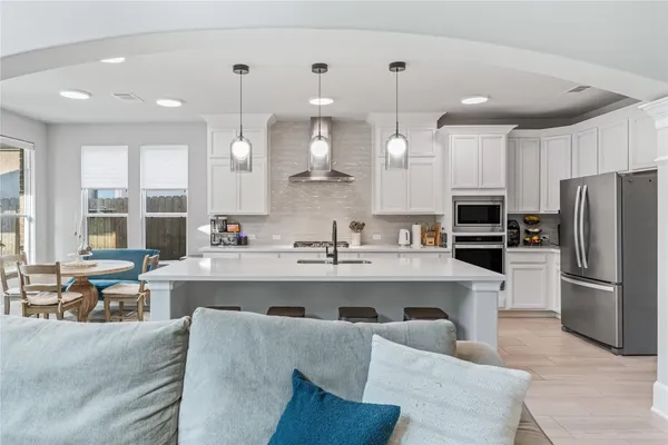 a large kitchen with a large counter top appliances and cabinets