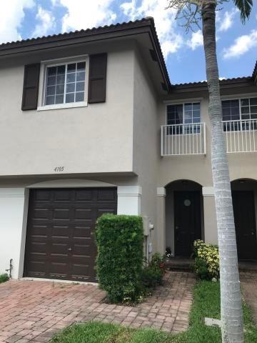 4105 Napoli Lake Drive Riviera Beach, FL 33410 - Photo 1 of 14 a front view of a house with garden