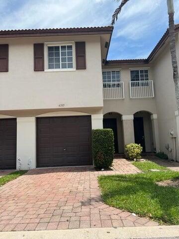 4105 Napoli Lake Drive Riviera Beach, FL 33410 - Photo 2 of 14 a front view of a house with a yard