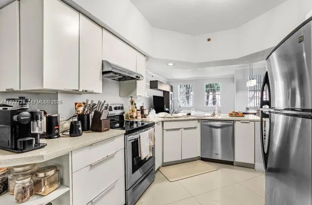 a kitchen with a sink a refrigerator and cabinets