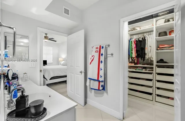 a view of walk in closet with clothes and shoes