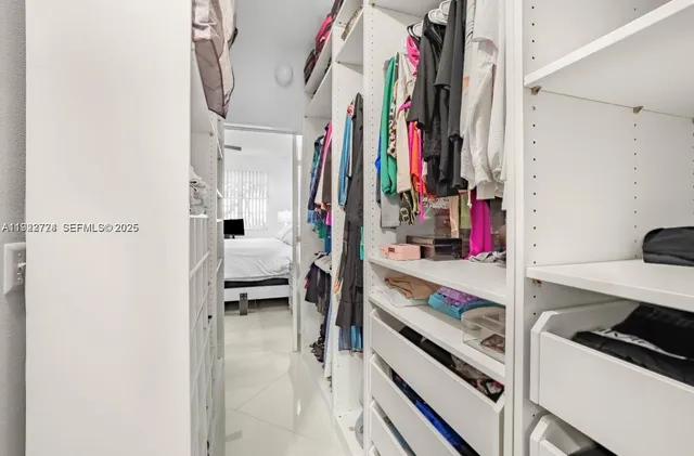 a view of walk in closet with clothes and shoes