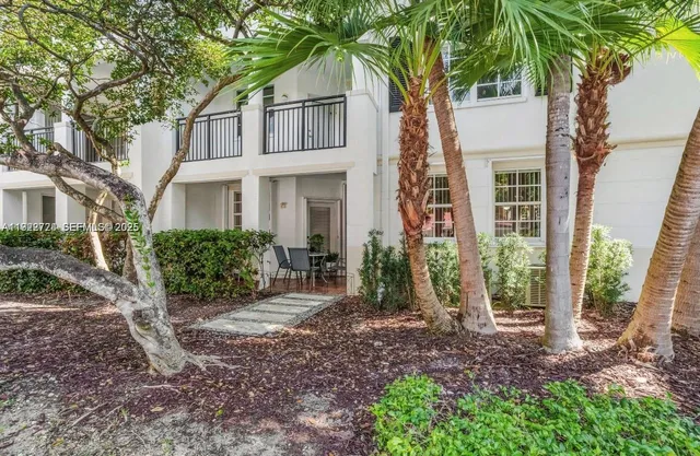 a view of a house with backyard and a tree