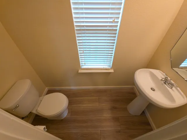 a bathroom with a toilet a sink and mirror
