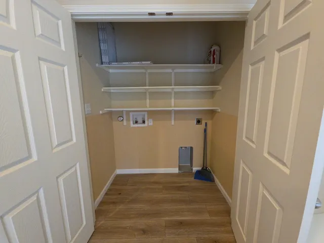 a view of a hallway with wooden floor and closet