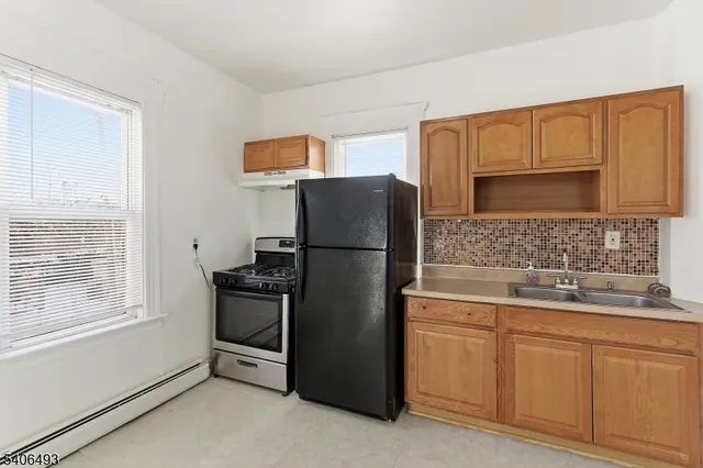 a kitchen with stainless steel appliances granite countertop a refrigerator sink and stove