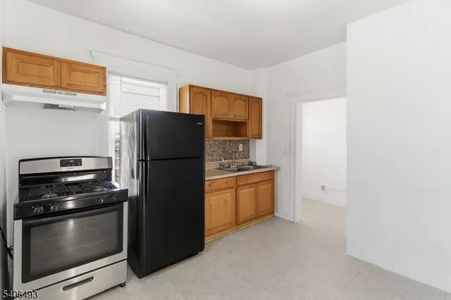 a kitchen with stainless steel appliances a refrigerator and a stove top oven