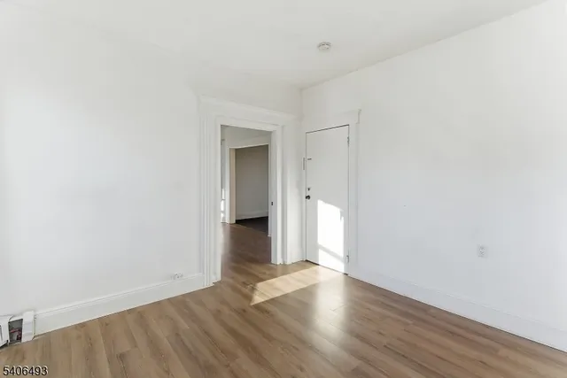 a view of a room with wooden floor and white walls