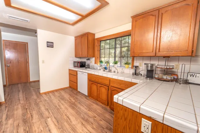 a large kitchen with stainless steel appliances granite countertop a stove a sink dishwasher and a refrigerator
