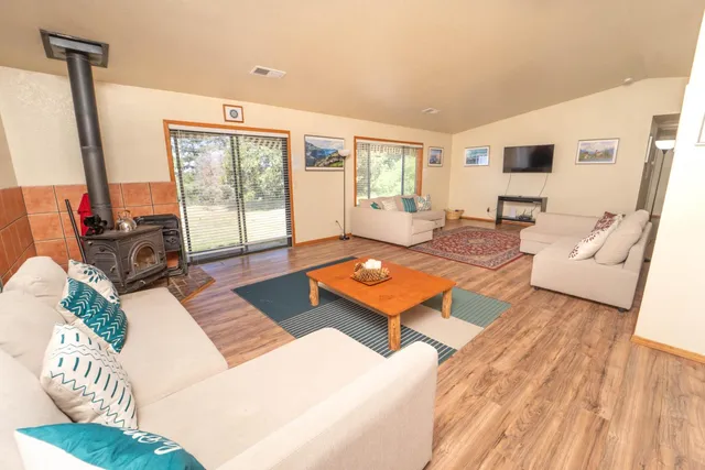 a living room with furniture a large window and wooden floor
