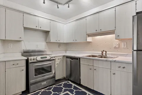 a kitchen with cabinets appliances and a sink