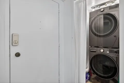 a utility room with dryer washer and a view of bathroom