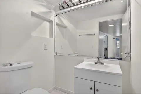 a bathroom with a sink mirror and toilet