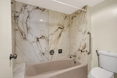 a bathroom with a shower a toilet and a shower