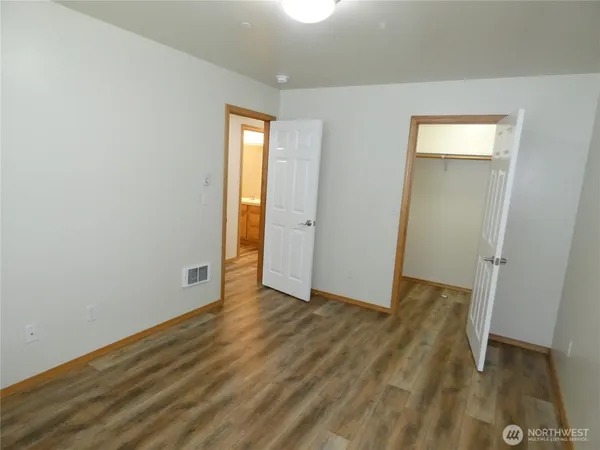an empty room with wooden floor and closet