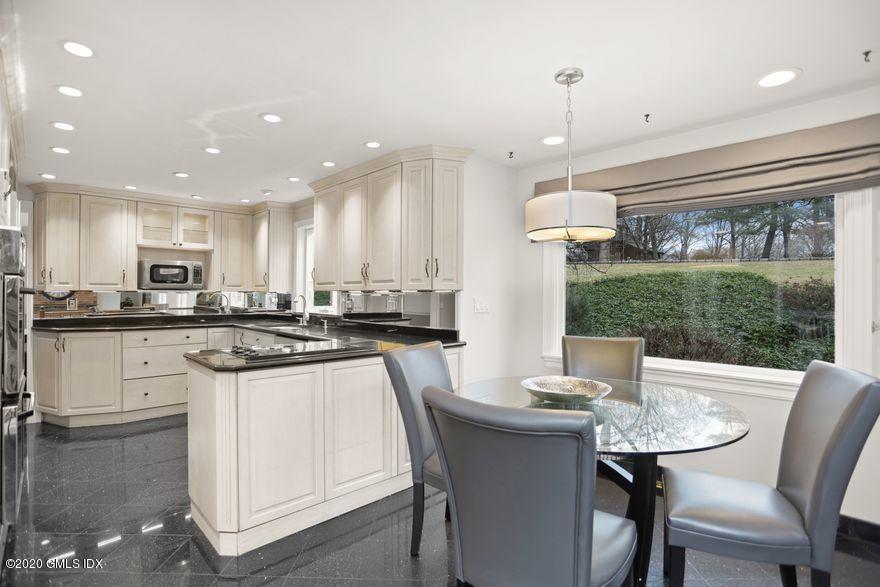 92 North Old Stone Bridge Road Cos Cob, CT 06807 - Photo 16 of 38 a kitchen with stainless steel appliances kitchen island granite countertop a table chairs sink and cabinets