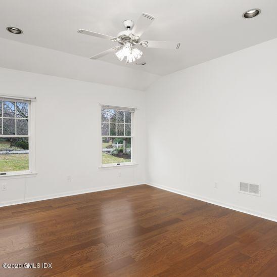92 North Old Stone Bridge Road Cos Cob, CT 06807 - Photo 23 of 38 an empty room with wooden floor chandelier fan and windows
