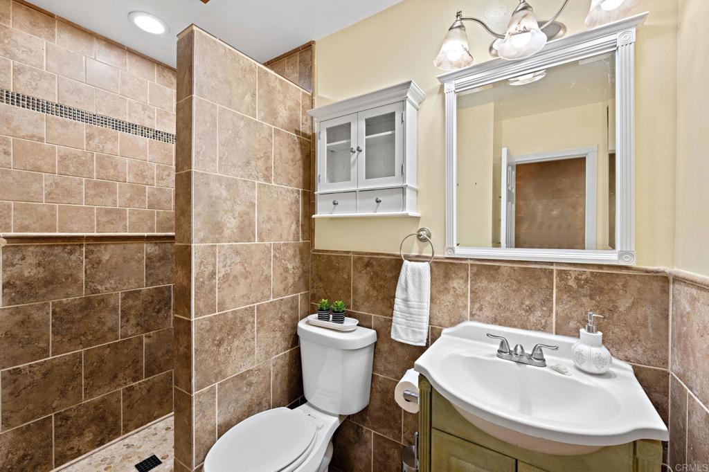 2042 Pheasant Run Road Fallbrook, CA 92028 - Photo 35 of 75 a bathroom with a sink and mirror with toilet