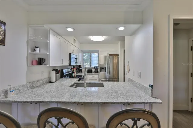 a living room with granite countertop kitchen island with stainless steel appliances granite countertop furniture and kitchen view