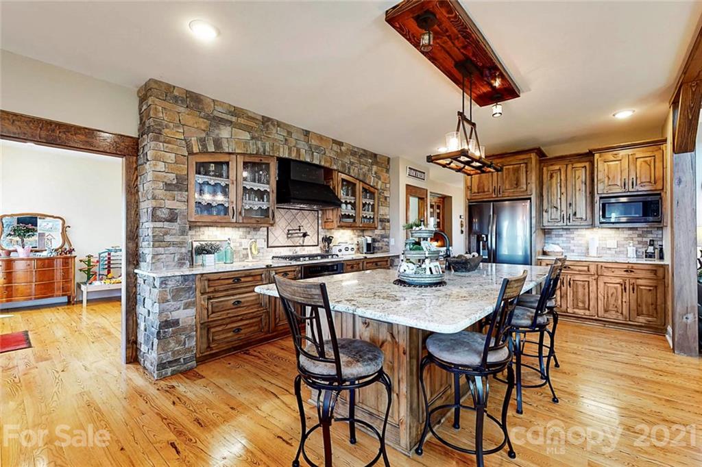 7555 Stokes Ferry Road Salisbury, NC 28146 - Photo 14 of 48 a kitchen with stainless steel appliances kitchen island granite countertop a table and chairs in it
