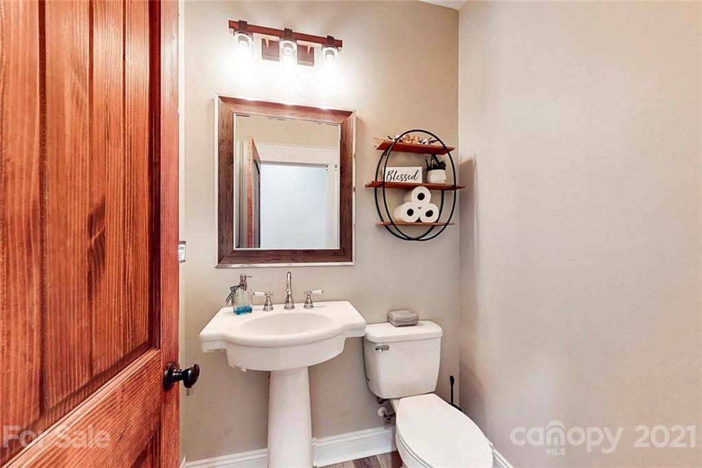 7555 Stokes Ferry Road Salisbury, NC 28146 - Photo 25 of 48 a bathroom with a toilet sink vanity and mirror