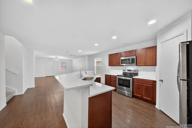 a large kitchen with stainless steel appliances kitchen island a cabinets and wooden floor