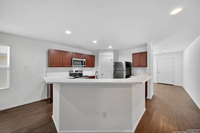 a view of kitchen with stainless steel appliances kitchen island sink stove and refrigerator